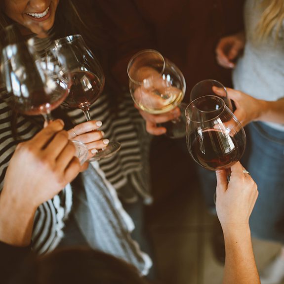 Women gathered around drinking wine